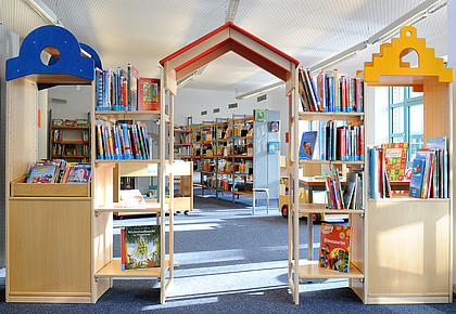 Tor-artiger Durchgang aus Bücherregalen als Eingang zum Kinderbereich einer Bücherei.