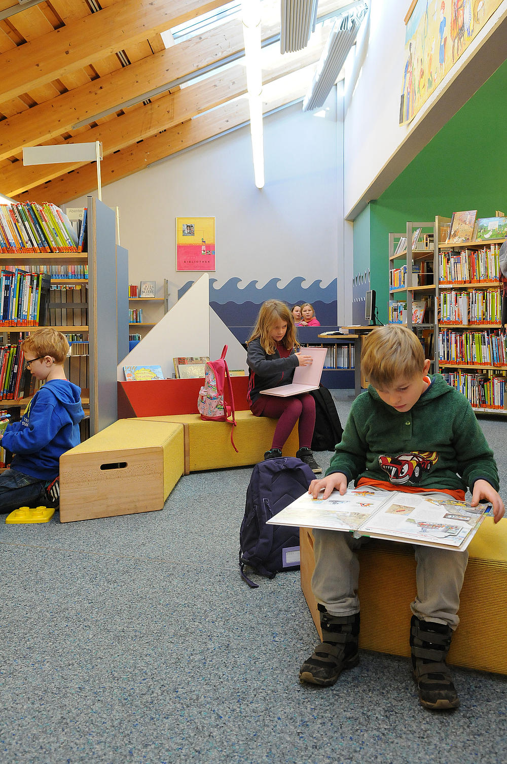 Kinder lesen in einer altersgerecht eingerichteten Abteilung der Bücherei Husum.