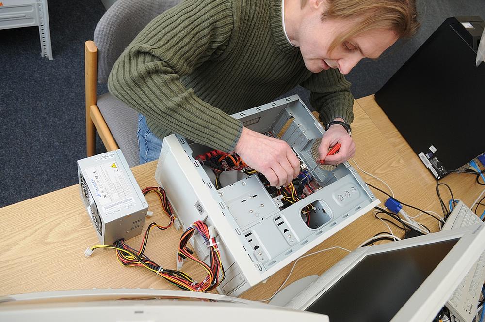 Ein Mitarbeiter übernimmt Hardware-Reparaturen im Zuge der EDV-Serviceleistungen.